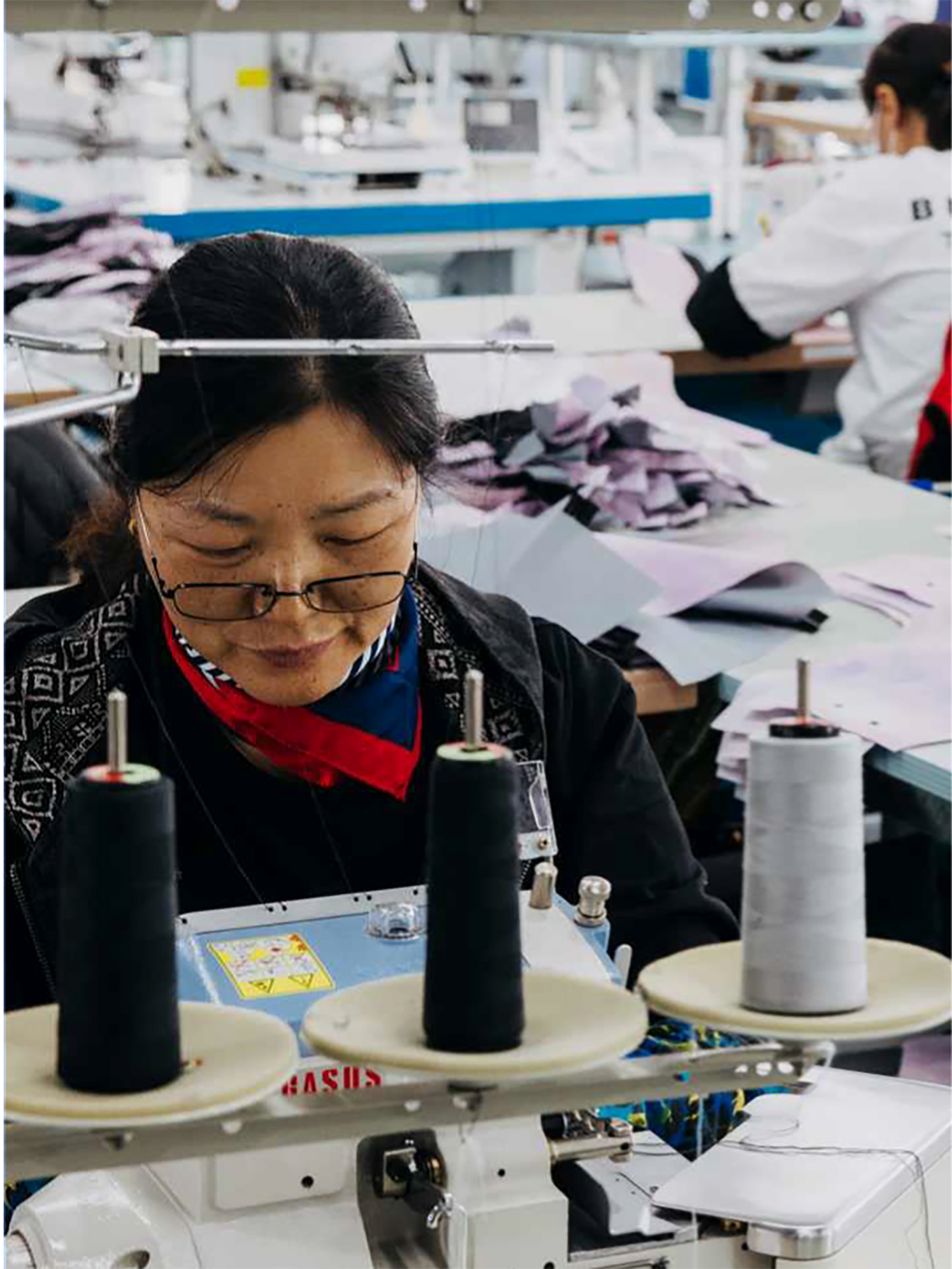 Person operating a sewing machine in a factory setting
