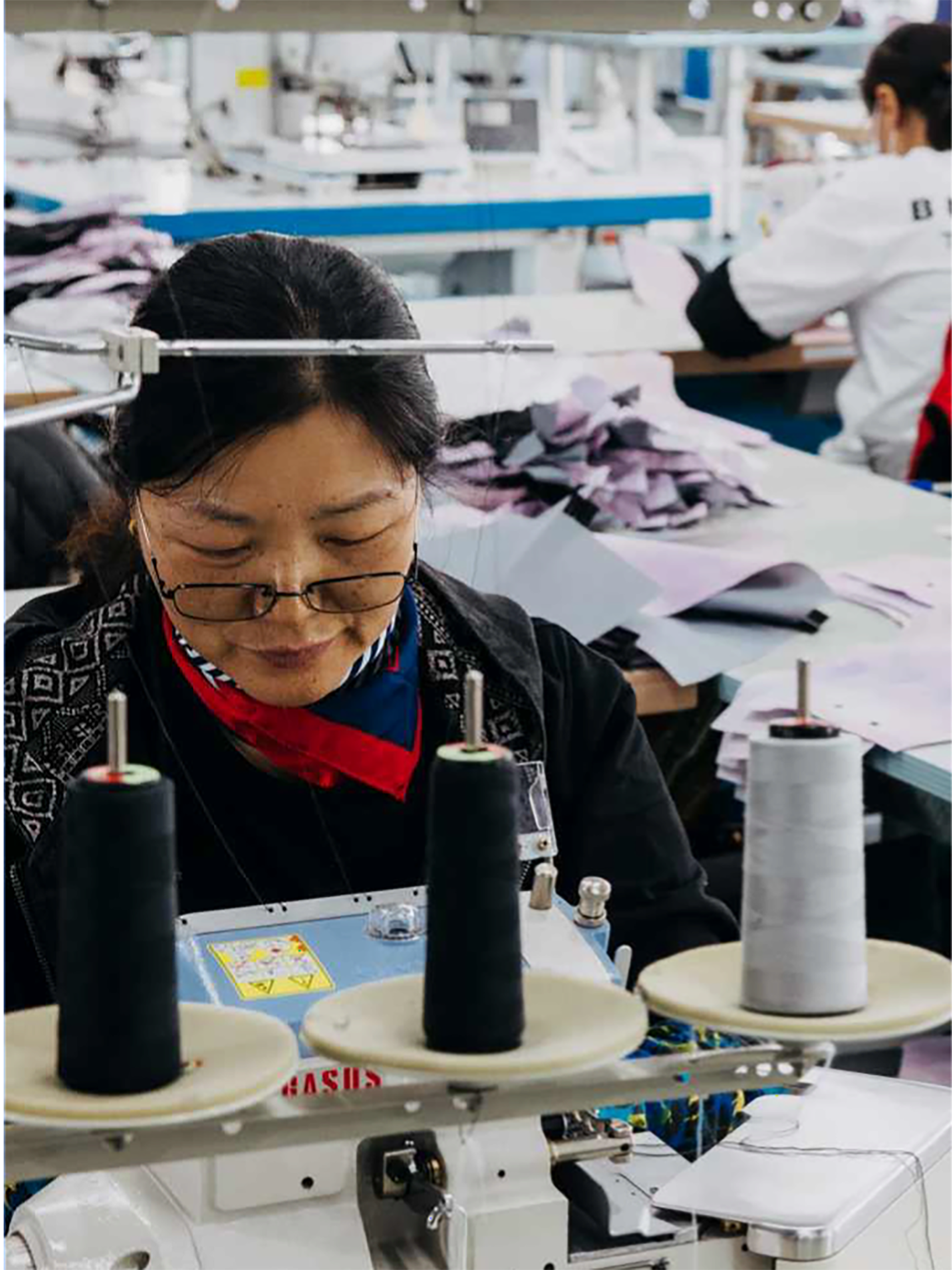 Person operating a sewing machine in a factory setting