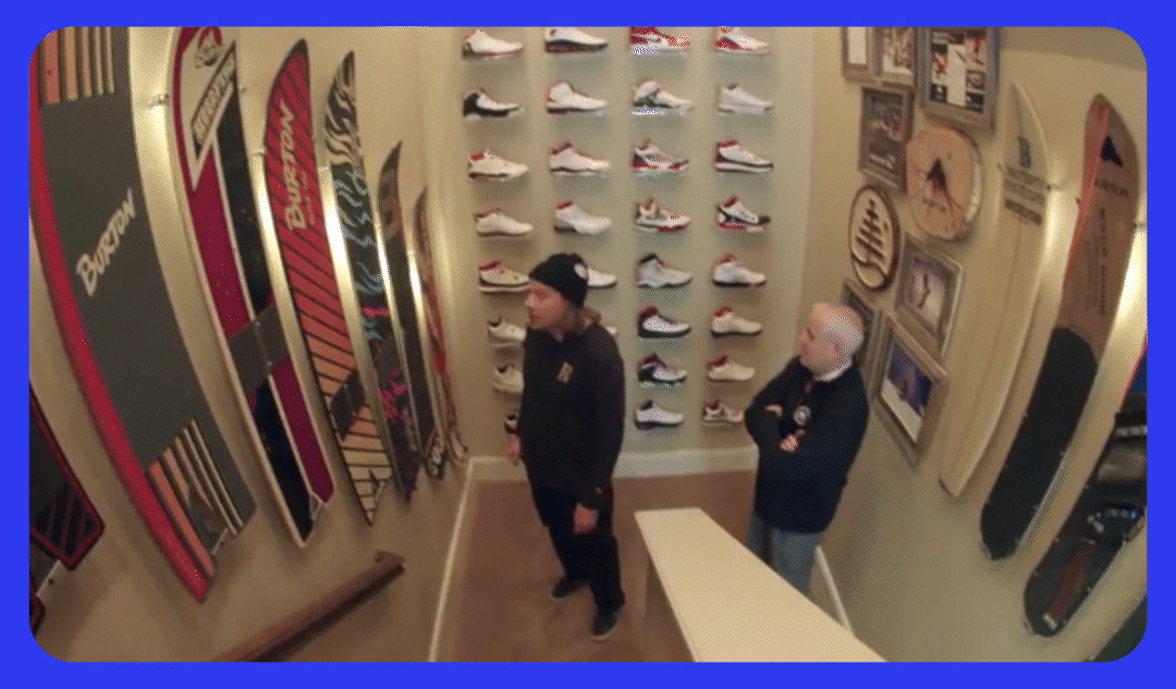 TK admiring a snowboard collector's snowboard collection in the stairwell of his home