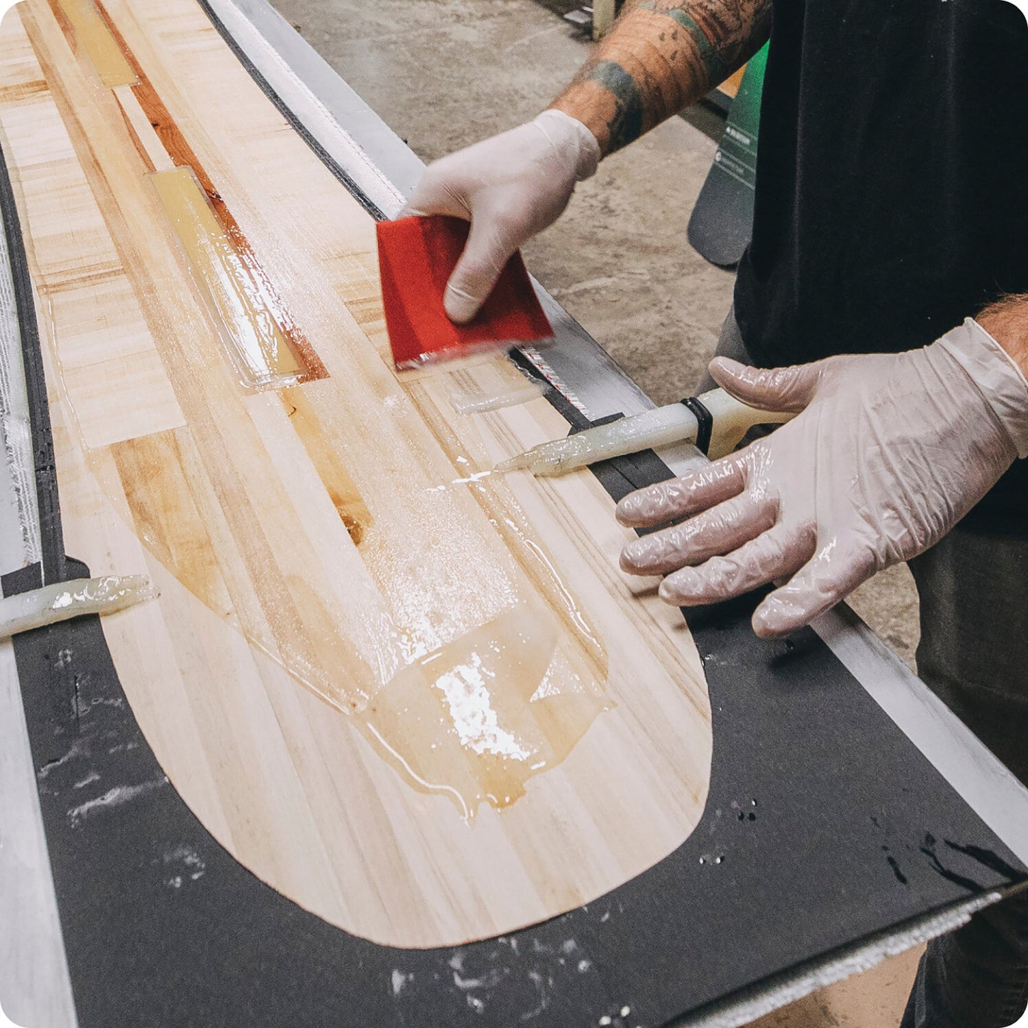 person applies bio-based epoxy to snowboard